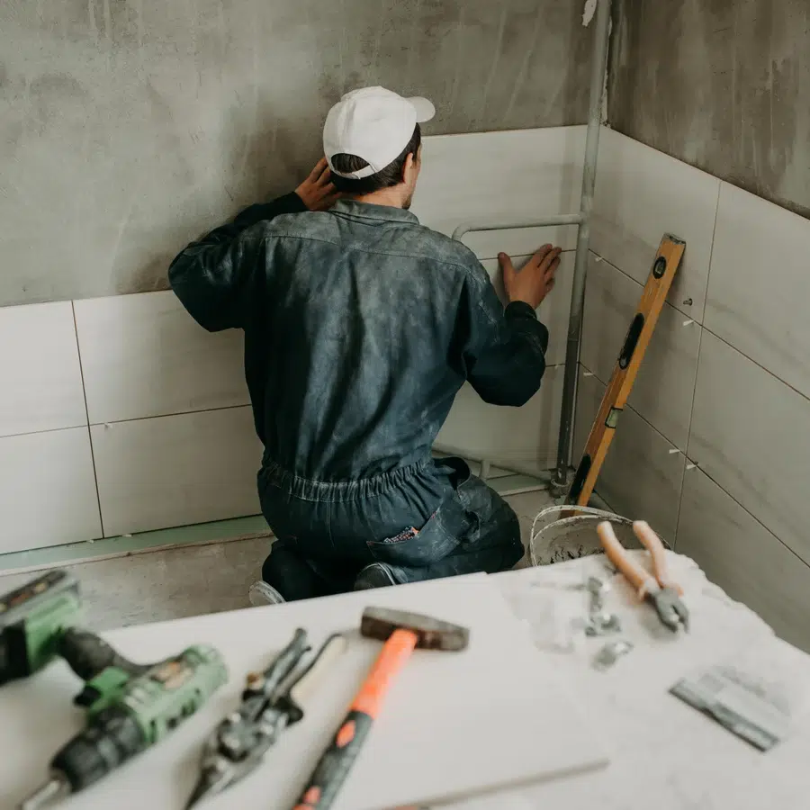 Homme posant du carrelage mural